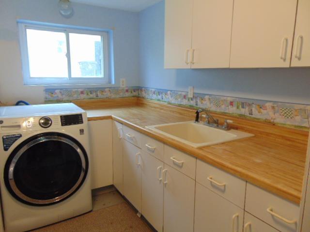 clothes washing area featuring washer / dryer and cabinet space