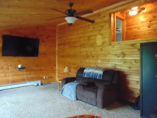 sitting room featuring carpet flooring, ceiling fan, and wood walls