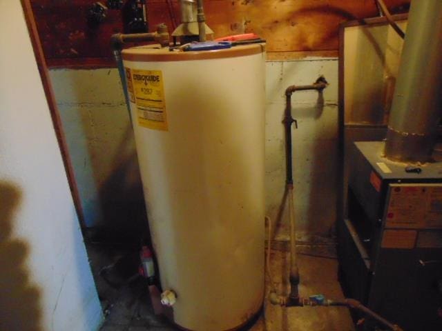 utility room featuring water heater and heating unit