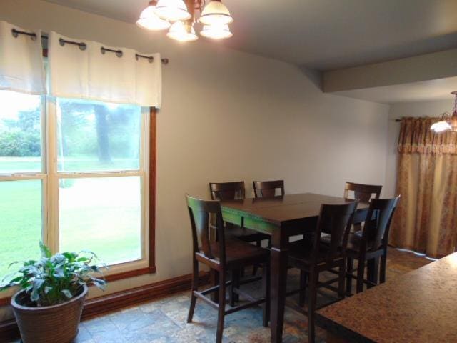 dining room with a chandelier and baseboards