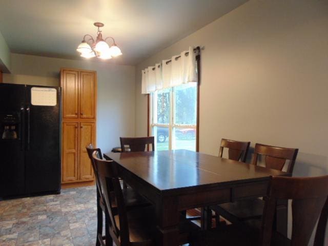 dining room featuring a chandelier and stone finish flooring