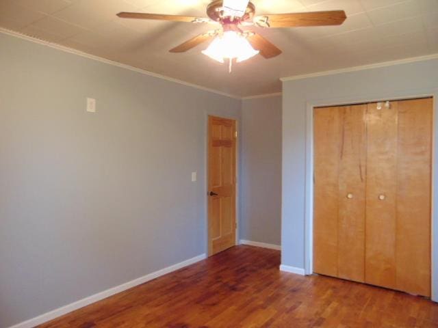 unfurnished bedroom with wood finished floors, ornamental molding, a closet, baseboards, and a ceiling fan