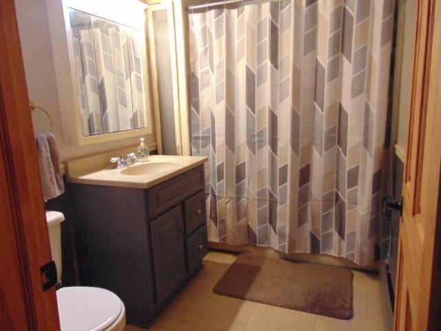 bathroom with toilet, vanity, and a shower with curtain