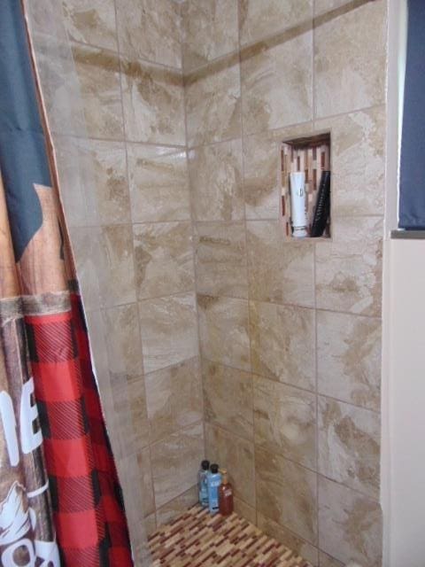 bathroom with tiled shower