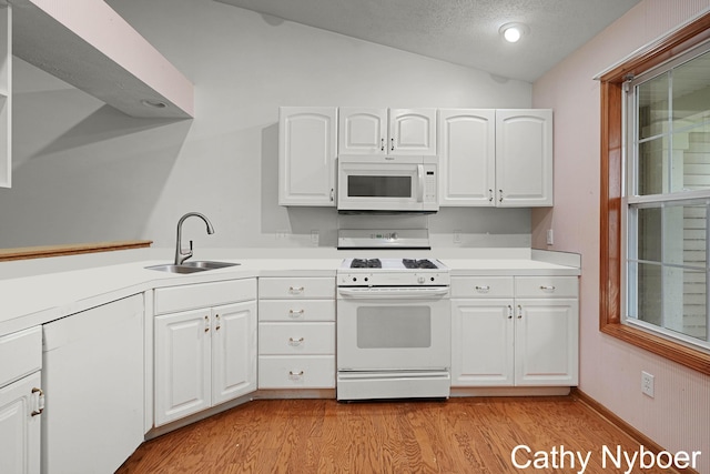 4330 Aspen Trails Dr NE, Grand Rapids, MI 49546 - kitchen featuring white appliances, a sink, lofted ceiling, light countertops, and light wood-style floors