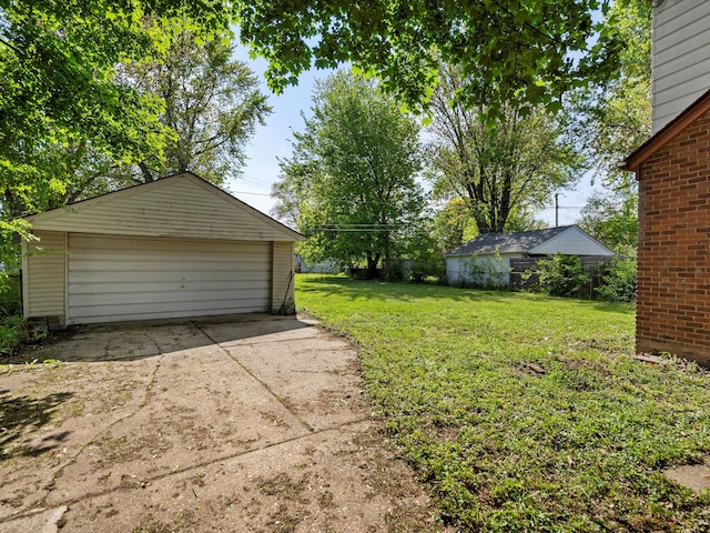 view of yard with a detached garage and an outbuilding