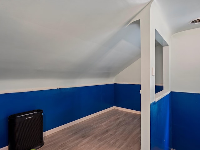 bonus room with wood finished floors, vaulted ceiling, and baseboards