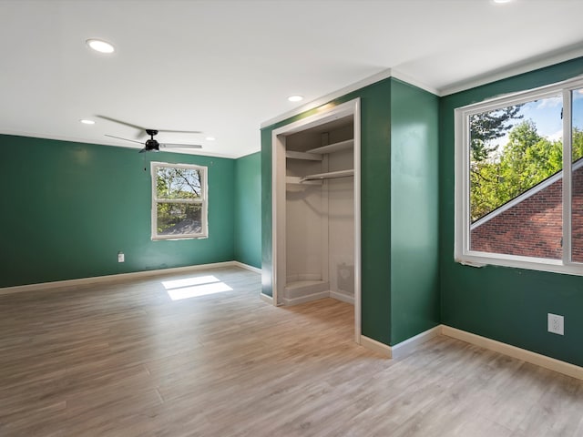 unfurnished bedroom with baseboards, wood finished floors, a closet, and recessed lighting
