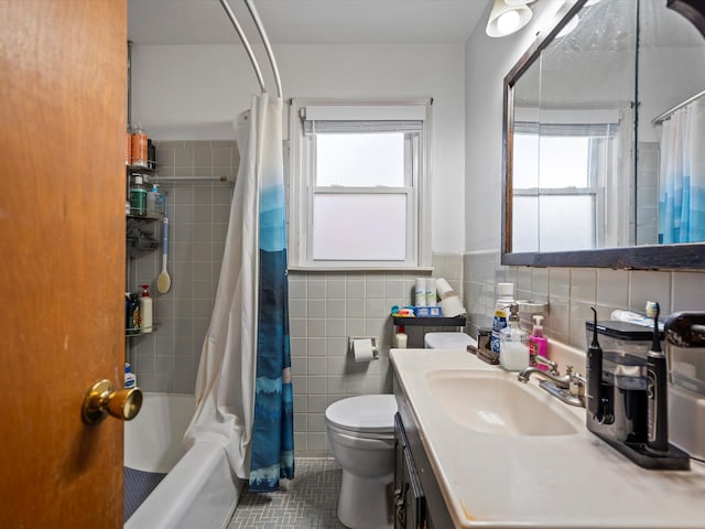 full bathroom with tile patterned floors, toilet, tile walls, healthy amount of natural light, and vanity