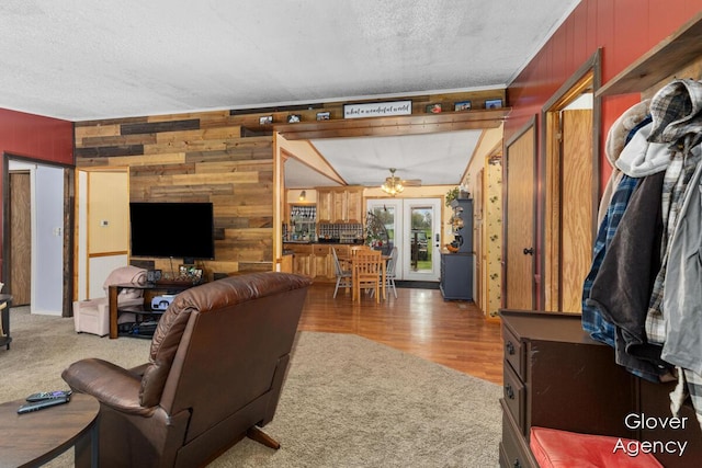 16617 W Stanton Rd, Pierson, MI 49339 - living area featuring wooden walls, a textured ceiling, french doors, and carpet