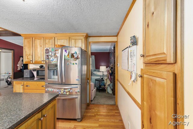 16617 W Stanton Rd, Pierson, MI 49339 - kitchen with light wood-style flooring, a textured ceiling, ornamental molding, dark countertops, and appliances with stainless steel finishes