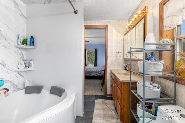 16617 W Stanton Rd, Pierson, MI 49339 - ensuite bathroom with a bathing tub, tile walls, ensuite bathroom, and vanity