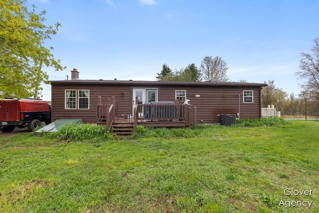 16617 W Stanton Rd, Pierson, MI 49339 - back of property with cooling unit, a chimney, a deck, and a lawn