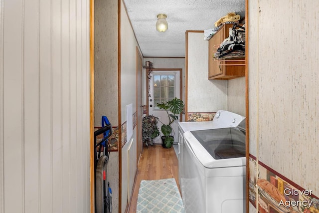 16617 W Stanton Rd, Pierson, MI 49339 - laundry area with washing machine and dryer, laundry area, light wood-style flooring, and a textured ceiling