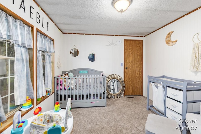 16617 W Stanton Rd, Pierson, MI 49339 - bedroom featuring ornamental molding, a textured ceiling, carpet, and a nursery area