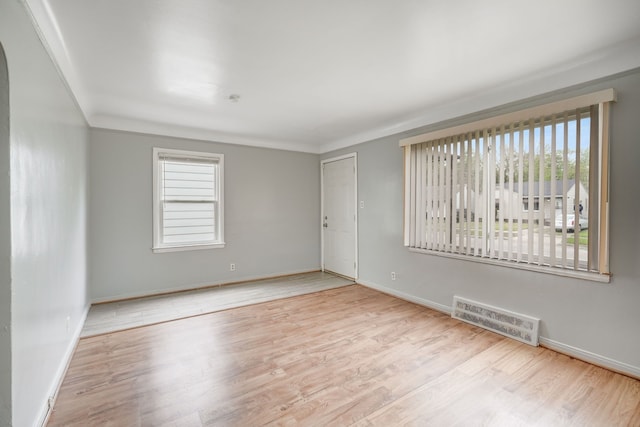 spare room featuring healthy amount of natural light, wood finished floors, and baseboards