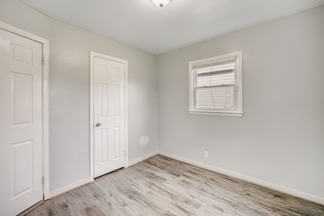 unfurnished bedroom with light wood-type flooring and baseboards