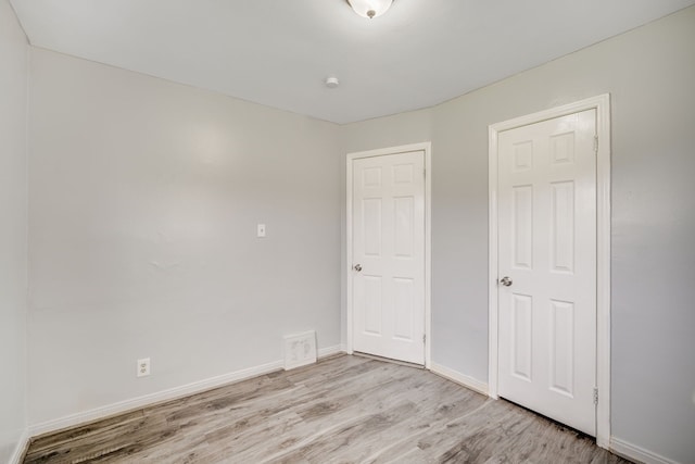 unfurnished bedroom featuring light wood-type flooring and baseboards