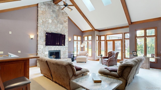 1947 Maplewood Ave, Bloomfield Hills, MI 48302 - living room featuring a stone fireplace, beamed ceiling, high vaulted ceiling, a skylight, and a ceiling fan
