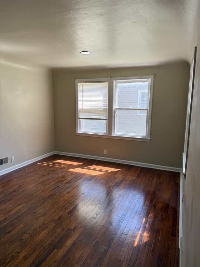 609 Buckingham Ave, Flint, MI 48507 - spare room featuring wood-type flooring, healthy amount of natural light, and baseboards