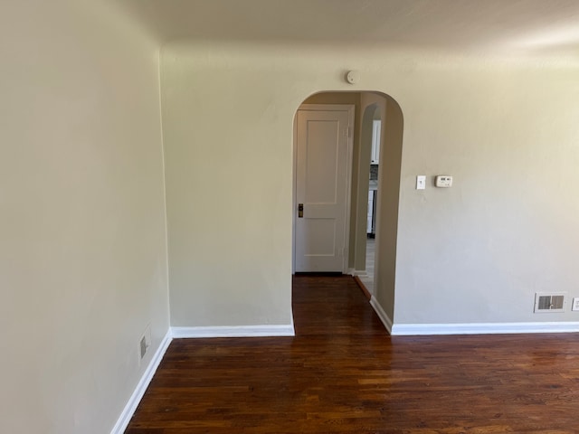 609 Buckingham Ave, Flint, MI 48507 - empty room with arched walkways, dark wood-style floors, and baseboards