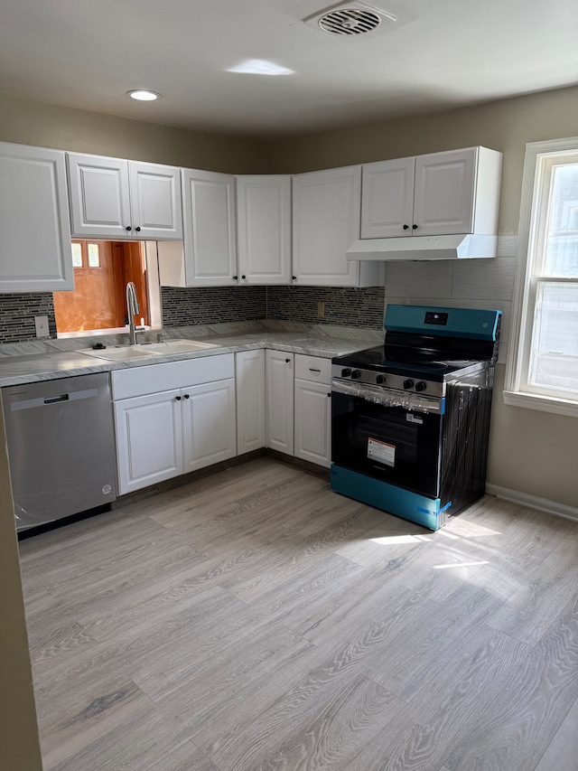 609 Buckingham Ave, Flint, MI 48507 - kitchen with appliances with stainless steel finishes, a sink, decorative backsplash, and light wood-type flooring