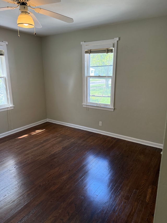 609 Buckingham Ave, Flint, MI 48507 - spare room featuring plenty of natural light, ceiling fan, dark wood-type flooring, and baseboards