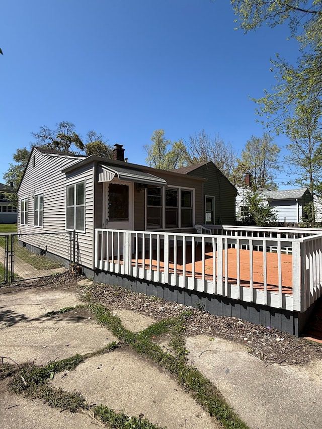 609 Buckingham Ave, Flint, MI 48507 - back of property featuring a deck, a chimney, and fence