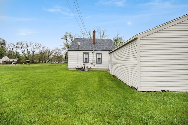 back of house featuring a yard and a chimney