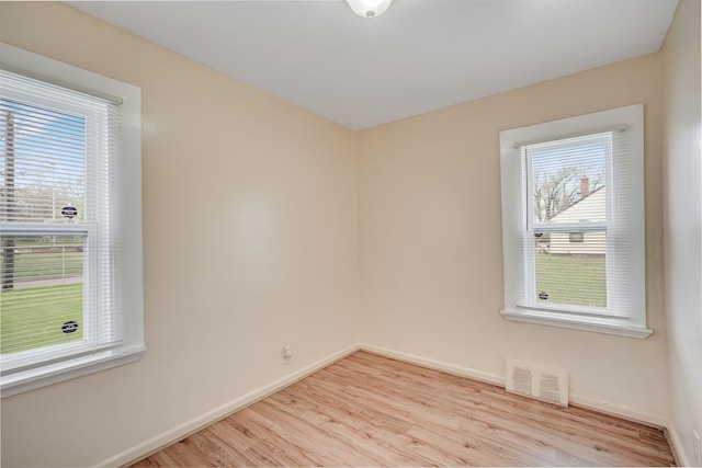 empty room with light wood-type flooring and baseboards