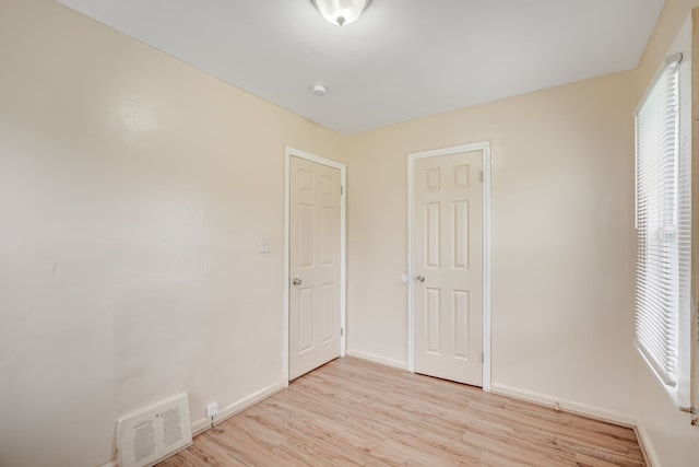 unfurnished bedroom featuring light wood-type flooring and baseboards