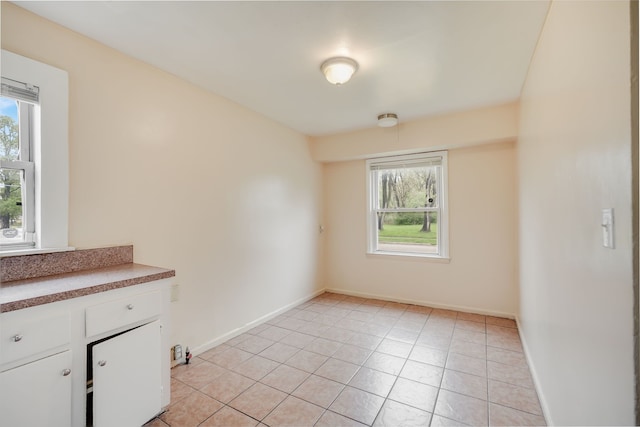 empty room featuring light tile patterned floors and baseboards