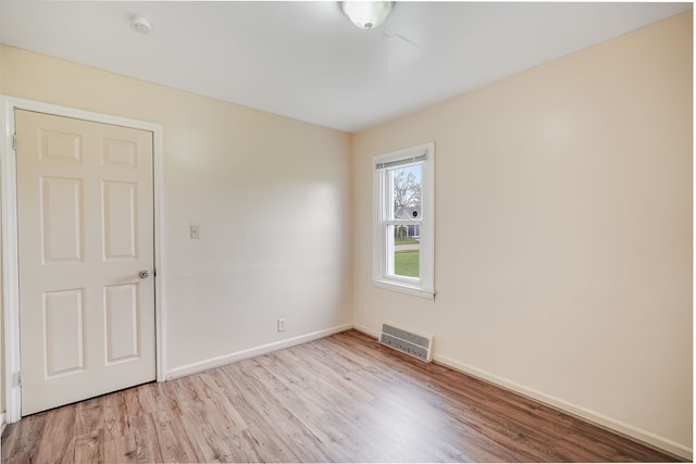 unfurnished room with light wood-style floors, baseboards, and a smoke detector