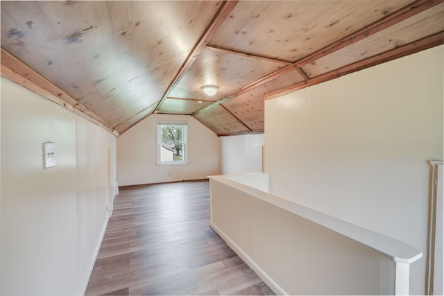 bonus room with baseboards, light wood-type flooring, and lofted ceiling