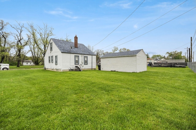 back of house featuring a lawn and a chimney