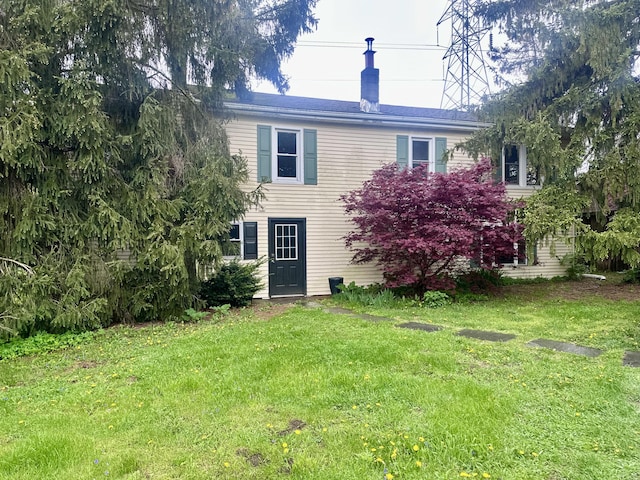 rear view of property featuring a yard
