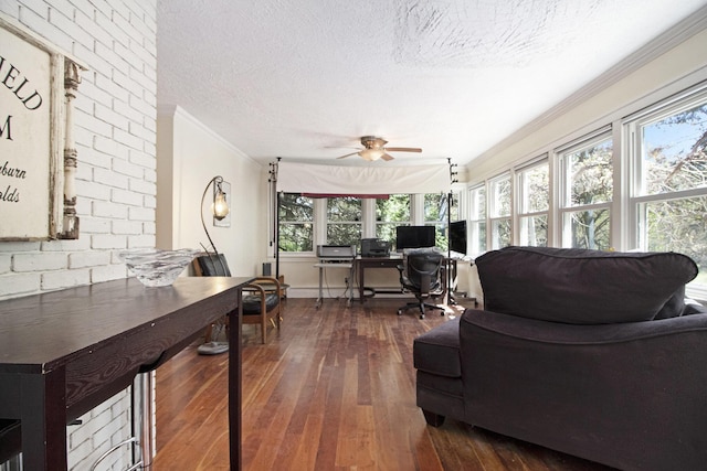living room with a textured ceiling, an office area, dark wood-style floors, ornamental molding, and a ceiling fan