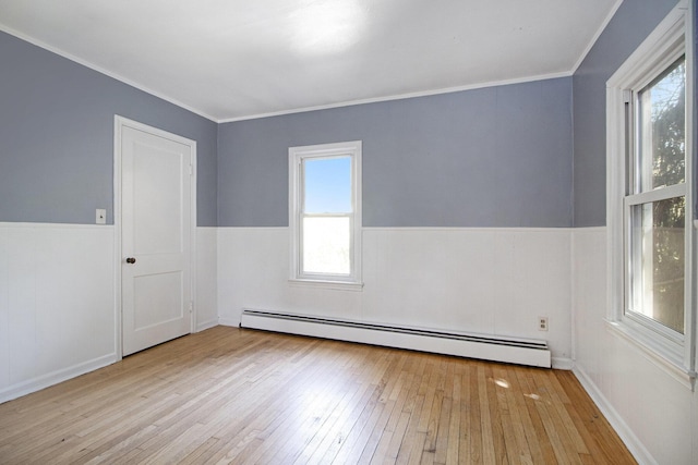 unfurnished room featuring a baseboard radiator, wood-type flooring, wainscoting, and ornamental molding