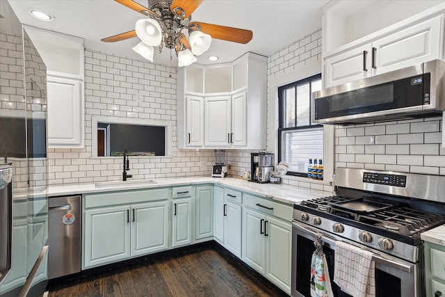 kitchen with a sink, tasteful backsplash, a ceiling fan, and appliances with stainless steel finishes