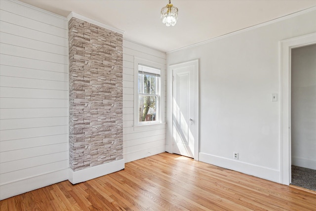 unfurnished room with baseboards, light wood finished floors, and crown molding