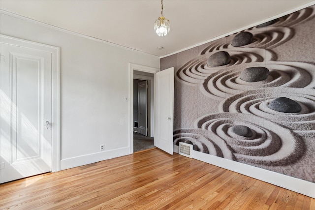 interior space featuring baseboards, ornamental molding, and wood finished floors