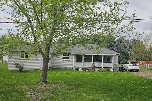 view of front of home featuring fence, a shingled roof, and a front lawn