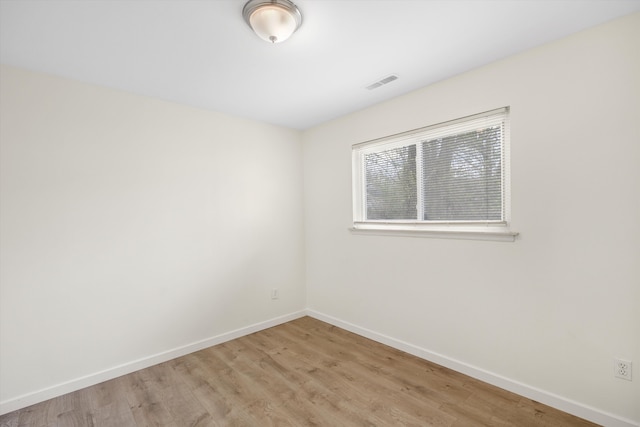 empty room featuring baseboards and light wood-style floors