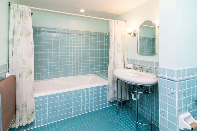 bathroom with tile patterned flooring, tile walls, and tiled shower / bath combo