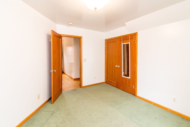 unfurnished room with light carpet and baseboards