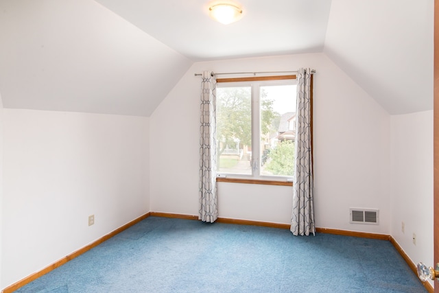 additional living space featuring baseboards, visible vents, carpet floors, and vaulted ceiling