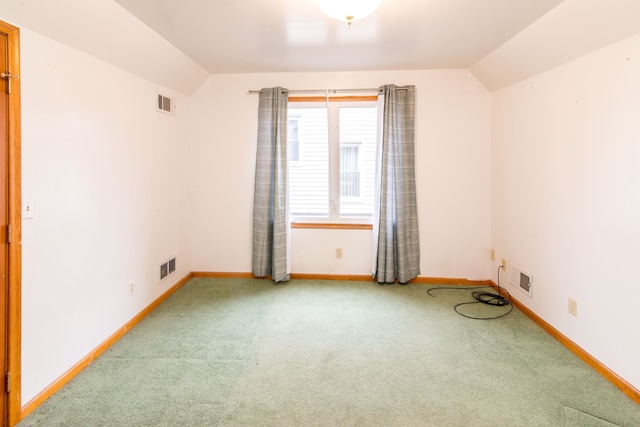 unfurnished room featuring lofted ceiling, carpet, baseboards, and visible vents