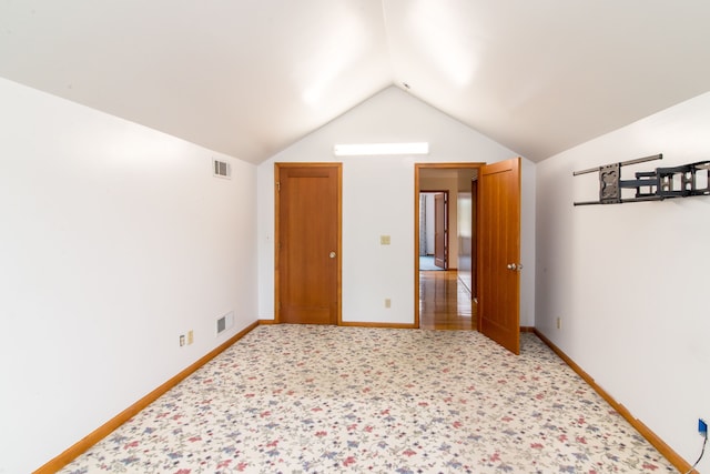 interior space featuring baseboards, light carpet, visible vents, and vaulted ceiling