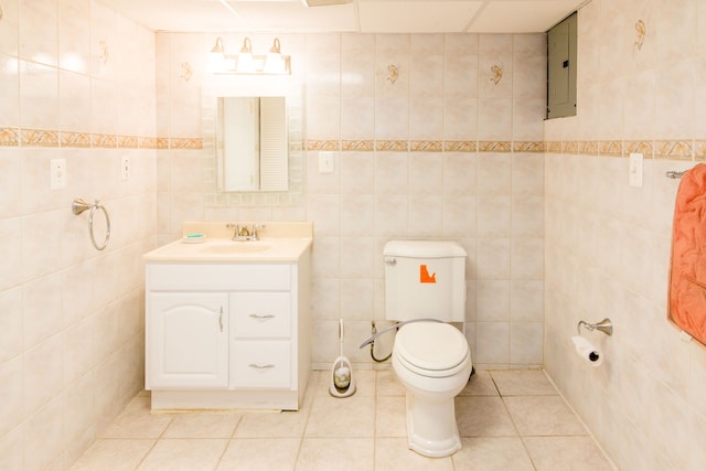 bathroom with toilet, electric panel, tile patterned floors, tile walls, and vanity