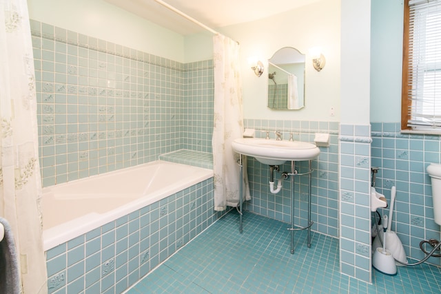 full bath with tiled shower / bath, tile patterned floors, tile walls, and wainscoting